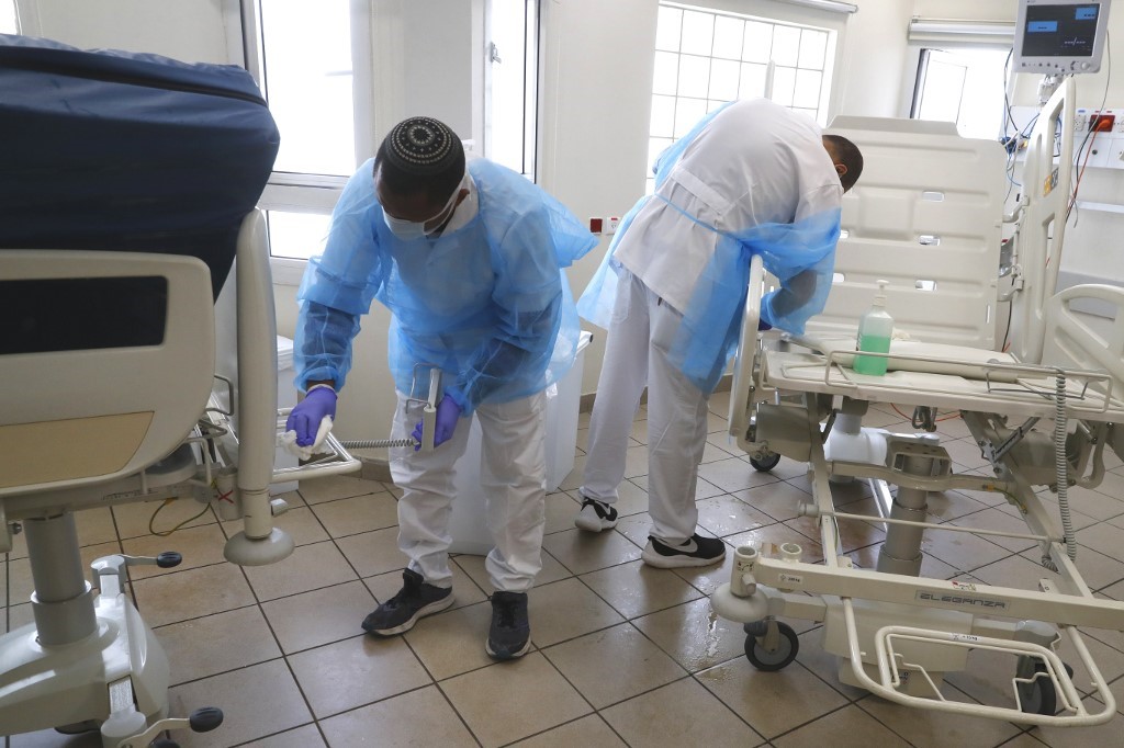 TÃ­tulo: Medical staff clean and disinfect a hospital segment dedicated to Covid-19 patients in Tel Aviv on 19 March (AFP)